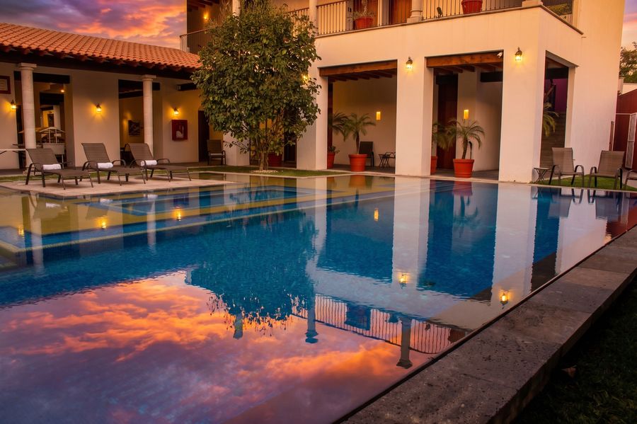 Alberca climatizada con camastros y cielo de atardecer en Radisson Cuernavaca