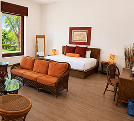 Habitación con sofá naranja y cama king size en Radisson Cuernavaca
